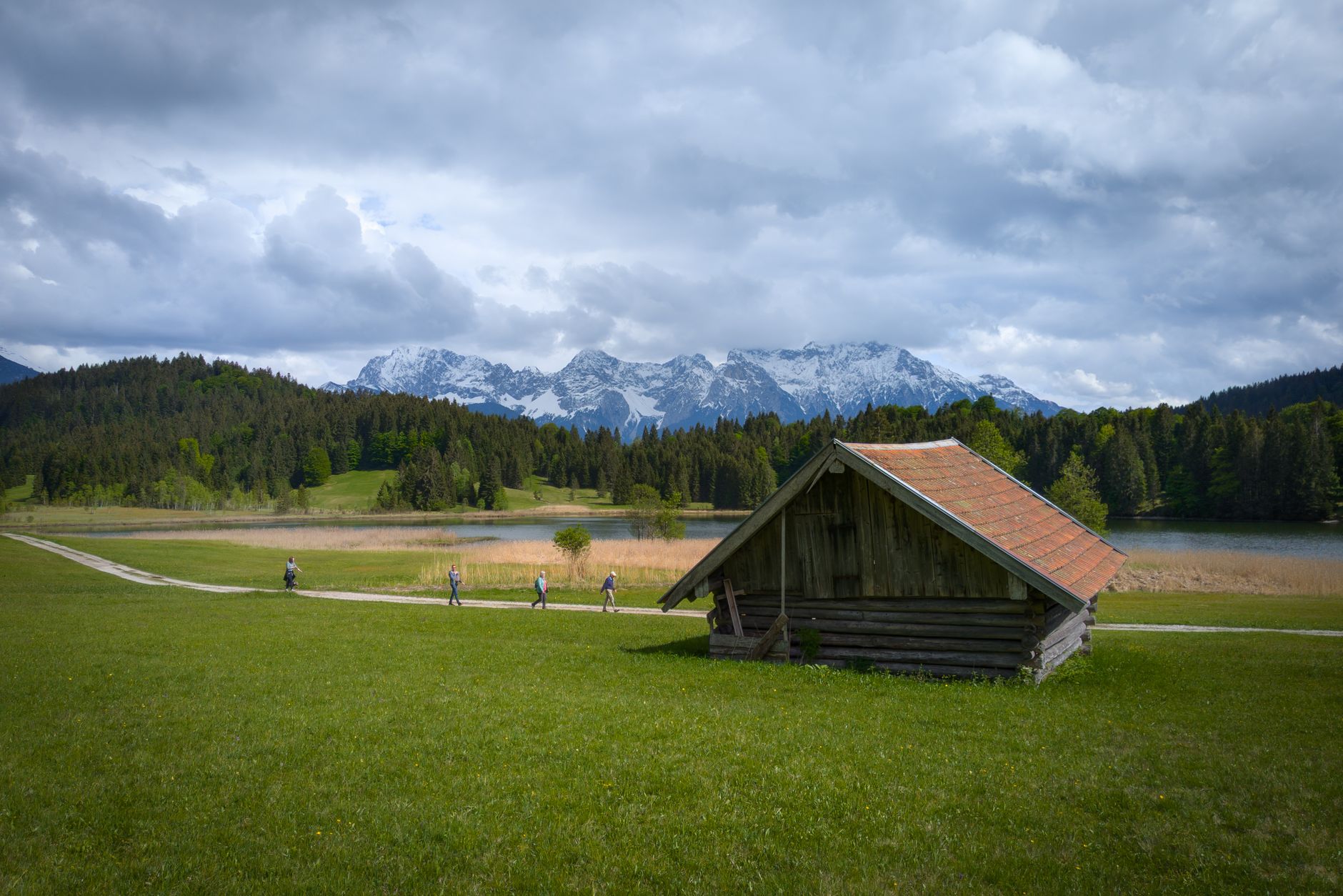 Rustic cabin in a scenic alpine meadow landscape with mountains and a peaceful lake view.